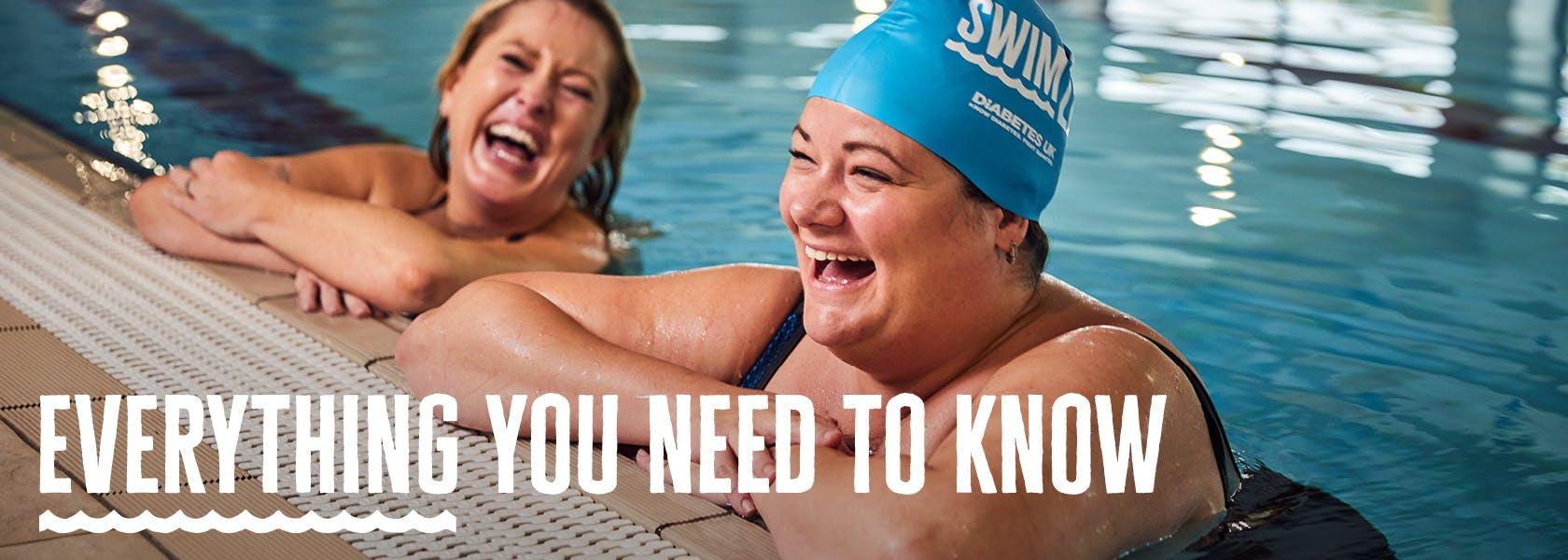Two swimmers smiling in the pool taking on Swim22. One wearing a Swim22 cap